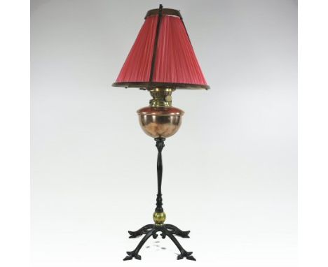 An Arts and Crafts wrought iron, copper and brass oil lamp and shade, by W. A. S. Benson, with a copper reservoir, the pleate