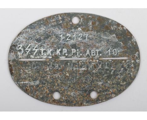 German Waffen-SS Identity Disc, oval zinc identity disc stamped “12127 3 SS T.K. K.P. Pi. ABT. 10”. Shows wear. We are not gu