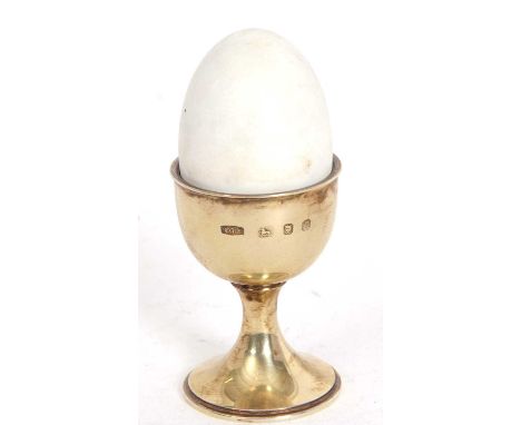 An Elizabeth II Anthony Gordon Elson silver gilt and enamel "Surprise" egg, the eggshell is white enamel and lifts off to rev