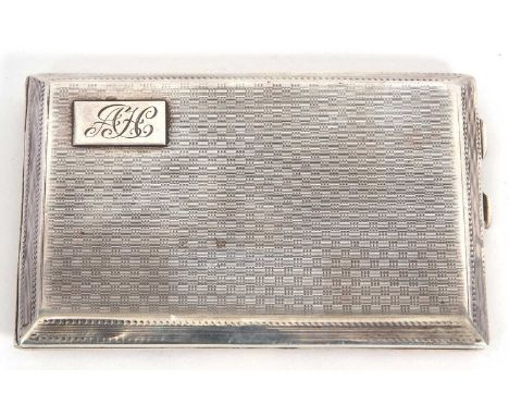 An Art Deco silver cigarette case of rectangular form having all over engine turned decoration and with one side having an in