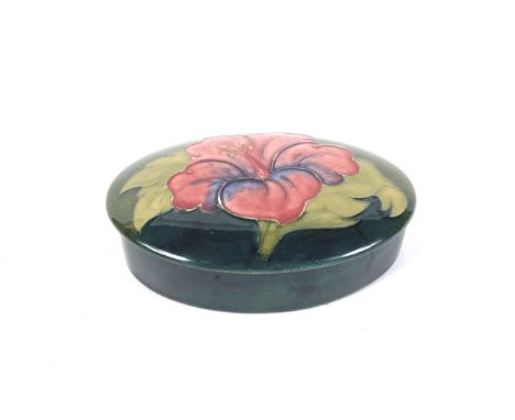 A Moorcroft green ground oval trinket box and cover in the hibiscus pattern. Impressed marks, with Moorcroft Late Queen Mary 