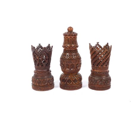 A 19th century carved coquilla nut pounce pot or shaker and two similar stands. The first of baluster form with screw-on pier