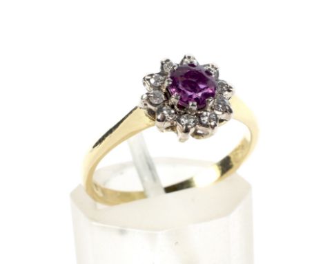A vintage 18ct gold, ruby and diamond cluster ring. Centred with a round mixed-cut ruby within an eight-cut diamond ten stone