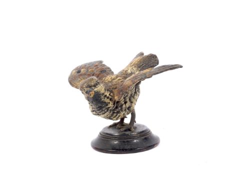 An early 20th century cold painted metal model of a bird on wooden base. WIth wings outstretched, on turned wooden base, 11.5