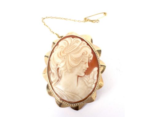 A vintage 9ct gold and shell cameo brooch. Depicting an unknown female profile within an undulating frame decorated with wire