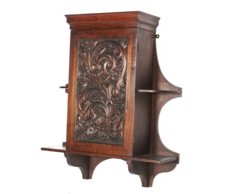 A Victorian carved mahogany hanging wall cupboard. The cupboard door densely carved with poppies and scrolling acanthus, fitt