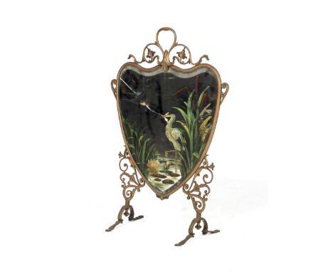 An early 20th century brass heart-shaped mirrored fire screen. WIth pierced foliate frame, the mirror painted with a heron in