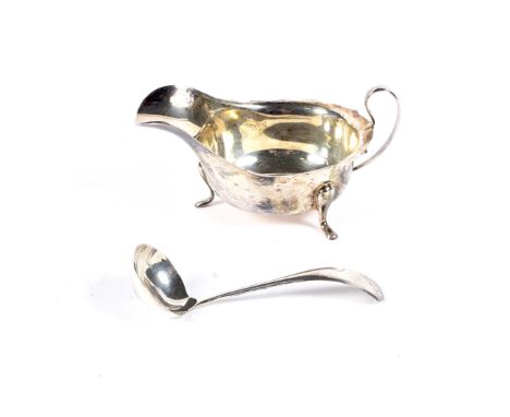 A silver sauce boat and a sauce ladle. The sauce boat with a shaped rim, a scroll handle and three pad feet, mark of Viners L