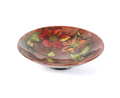 A Moorcroft footed dish. Tubelined with orange flowers on a mottled flambe ground, printed, painted and impressed marks, 18.5
