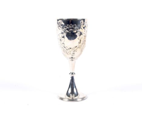 A late Victorian silver goblet. Embossed with foliate scrolls and two cartouches, on a knopped stem and round foot, mark of J