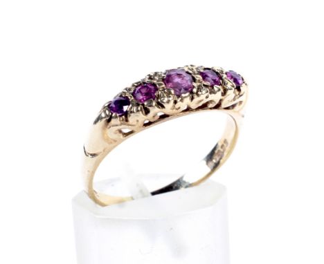 A vintage 9ct gold and ruby five stone cast 'carved half-hoop' ring in late Victorian style. The pale, round mixed-cut stones
