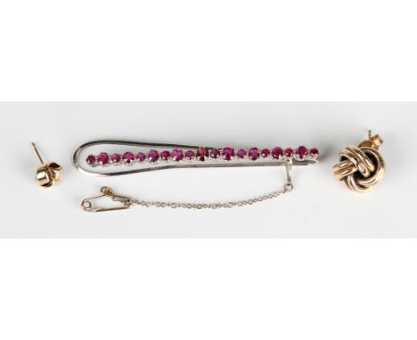 A white gold and ruby tie slide, mounted with a row of variously cut rubies, unmarked, weight 6.2g, length 6.3cm, a 9ct gold 