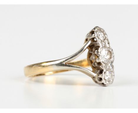 A gold and diamond three stone ring, mounted with a row of circular cut diamonds between 'V' shaped shoulders, unmarked, weig