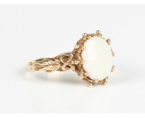 A 9ct gold ring, claw set with an oval opal between cast shoulders, London 1977, weight 3g, ring size approx N1/2.Buyer’s Pre