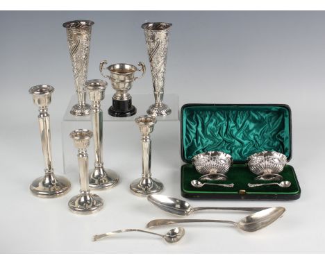 A pair of late Victorian silver salts of oval half-reeded form, embossed with a band of flowers and leaves, each raised on a 