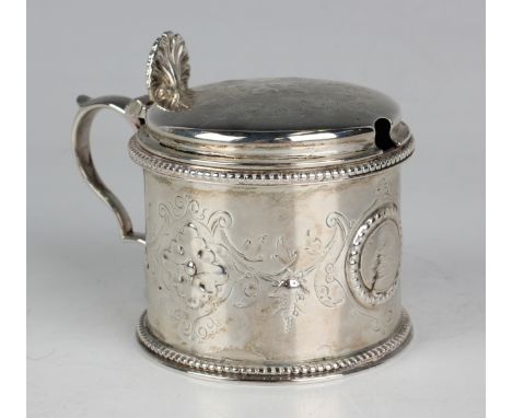 An early Victorian silver cylindrical mustard, the engraved hinged lid with scallop shell thumbpiece above a similarly decora