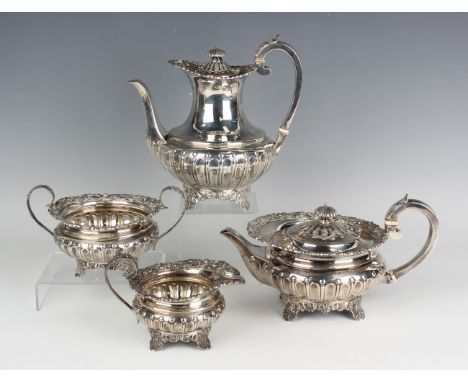 An Edwardian silver four-piece tea set, comprising teapot, hot water pot, milk jug and sugar bowl, each with cast foliate rim