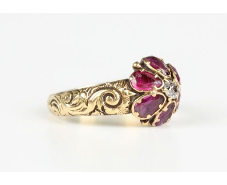 A Victorian gold, ruby and diamond cluster ring, claw set with the cushion cut diamond within a surround of six pear shaped r