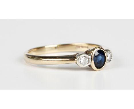 A 9ct gold ring, collet set with an oval cut sapphire between two collet set circular cut diamonds, weight 2.6g, ring size ap