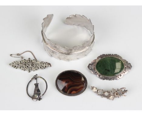 A silver bangle in the form of a feather, weight 40.2g, inside width 6.2cm, and five silver brooches, including one mounted w