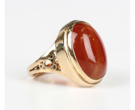 A 9ct gold ring, collet set with an oval cabochon banded cornelian between pierced shoulders, London 1985, weight 6.5g, ring 