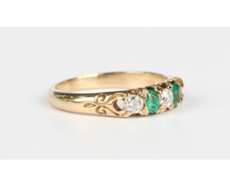 A gold, emerald and diamond ring, mounted with two variously cut emeralds alternating with two cushion cut diamonds, detailed