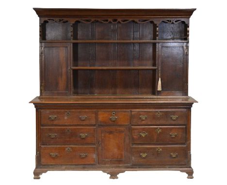 Late 18th/ early 19th century oak dresser, two shelf delft rack, incorporating cupboards, the base with seven drawers and a c