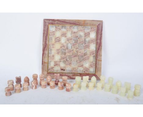 A vintage 20th century onyx chess set together with chess board. Set is complete. King measures 4.2cm.&nbsp;Chess board measu