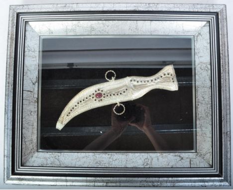 A 20th century Indian white metal Jambiya dagger and sheaf. The dagger having filigree work to handle and case and being set 