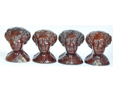 A set of four Victorian 19th century treacle-glazed pottery sash window rests/stoppers in the shape of women heads. Each rest