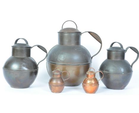 An assortment of vintage 20th century copper milk jugs of graduating form. Three being marked up for J. T. Laine Guernsey and
