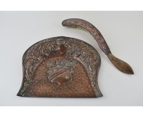 A copper crumb tray with original brush. Suit of armour helmet design with armorial shield. 29cm x 25cm.