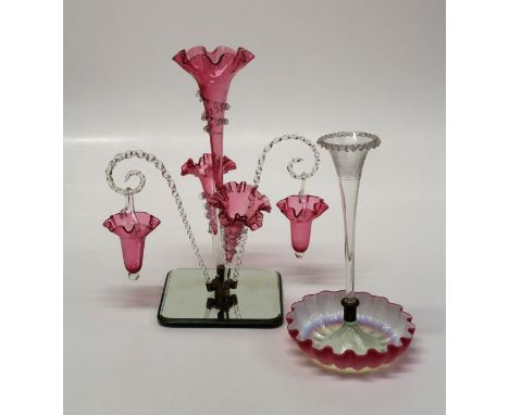 A Victorian cranberry and clear glass epergne of three trumpets and two wrythen canes each supporting an inverted bell shape 