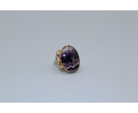 A 9ct gold Celtic style ring, set with a large cabochon of Blue John, size R.&nbsp;Gross weight approximately 11.7gm