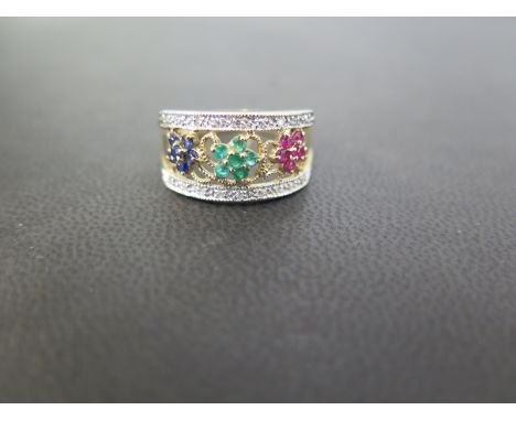 A 9ct gold multi-gem band ring - The ruby, sapphire and emerald clusters to the diamond sides - Hallmarked Birmingham - Ring 