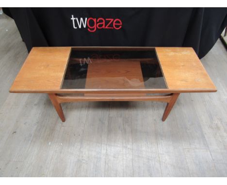 A teak coffee table with a smoked glass inset panel to top, undertier shelf, 136cm long x 51cm x 43cm high 