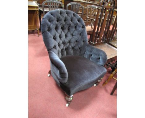 A Mid XIX Century Armchair, upholstered in a black button back upholstery, on walnut turned feet.