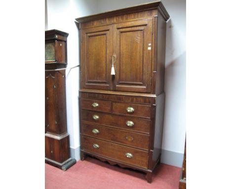 An Early XIX Century Oak and Mahogany Press, the top having stepped cornice, panelled doors with two internal shelves and thr