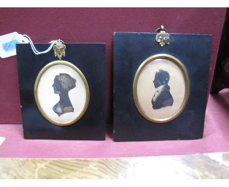 An Early XIX Century Silhouette Portrait of a Young Gentleman, oval, in papier maché rectangular frame with symbols of the Un