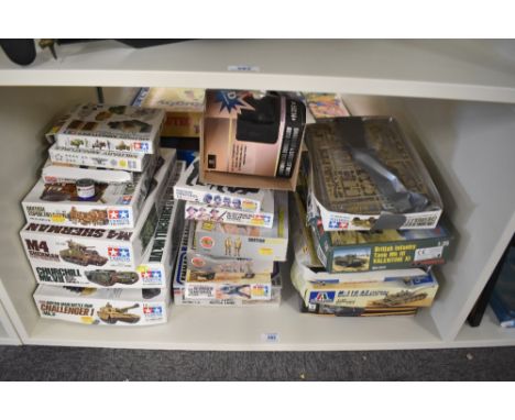 A shelf of Tamiya, Airfix, Itaileri and similar Military Kit Boxes, most started or empty, some have more pieces than others