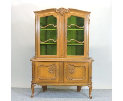 A French style carved light oak cabinet bookcase, on cabriole legs, 125cm