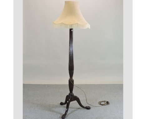 A mahogany turned and fluted standard lamp, on paw feet, with shade, 186cm high overall