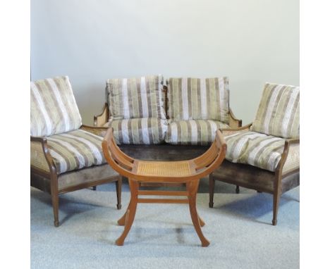 An early 20th century single cane sofa, 122cm, together with two armchairs, and a camel stool