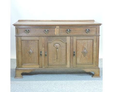 An Edwardian carved oak sideboard, on bracket feet, 152cm