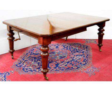 A LATE VICTORIAN OAK DINING TABLE, ON GLOBE KNOPPED OCTAGONAL LEGS WITH BRASS CASTERS, WITH A LEAF, 121 X 176CM