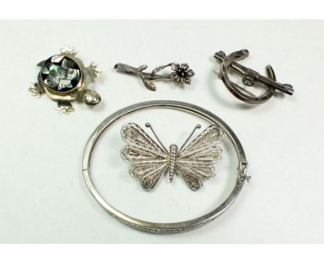 A silver bangle and four silver brooches. 