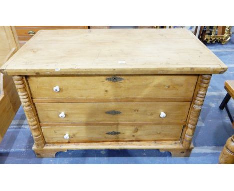 Old pine chest of three drawers flanked by turned split pilasters and on bracket feet, some ceramic knob handles, 106cm wide 