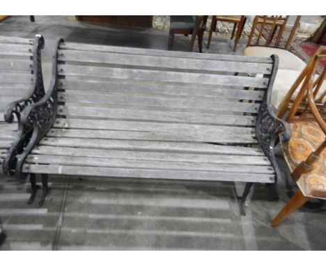 Pair of slatted garden bench seats with decorative iron supports 