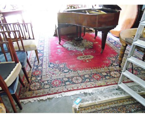 Eastern wool carpet, with central cream floral decorated medallion on a red ground, within cream and blue floral borders 367 