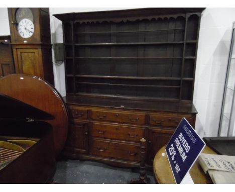 Georgian oak dresser, the open shelf plate rack with carved frieze, with two frieze drawers and three central graduated drawe